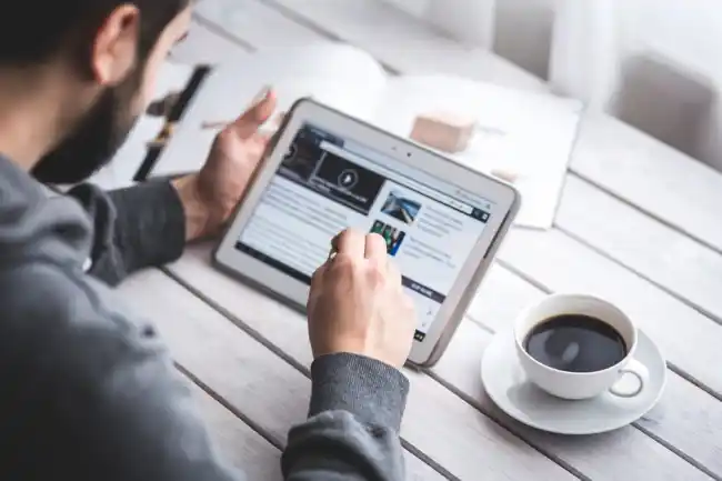 Homme utilisant un iPad à une table.