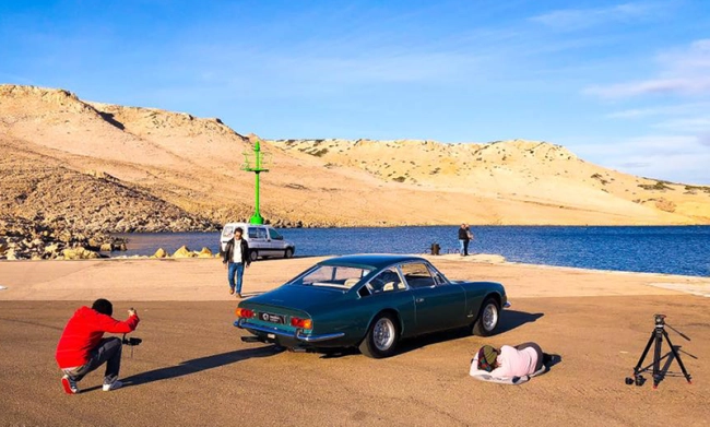 Un photographe prenant des photos d'une voiture classique.