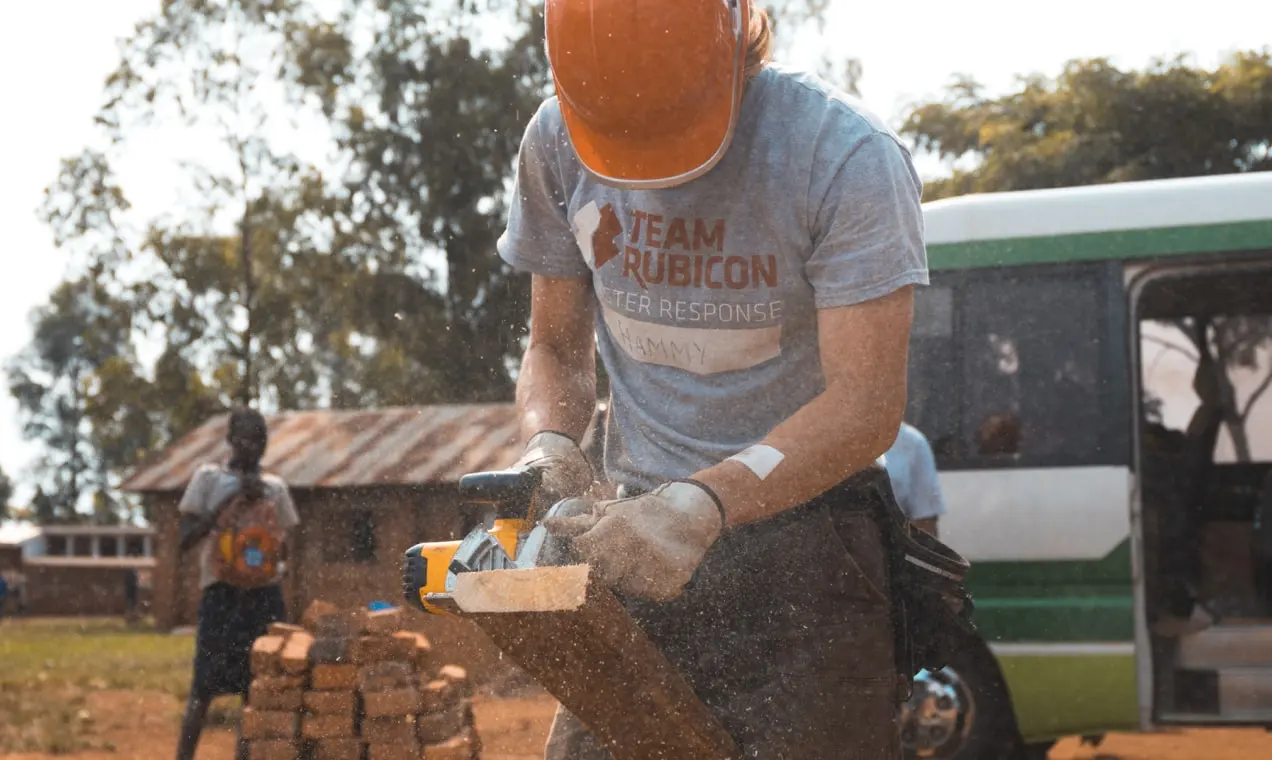 voluntário sem fins lucrativos serrando uma prancha