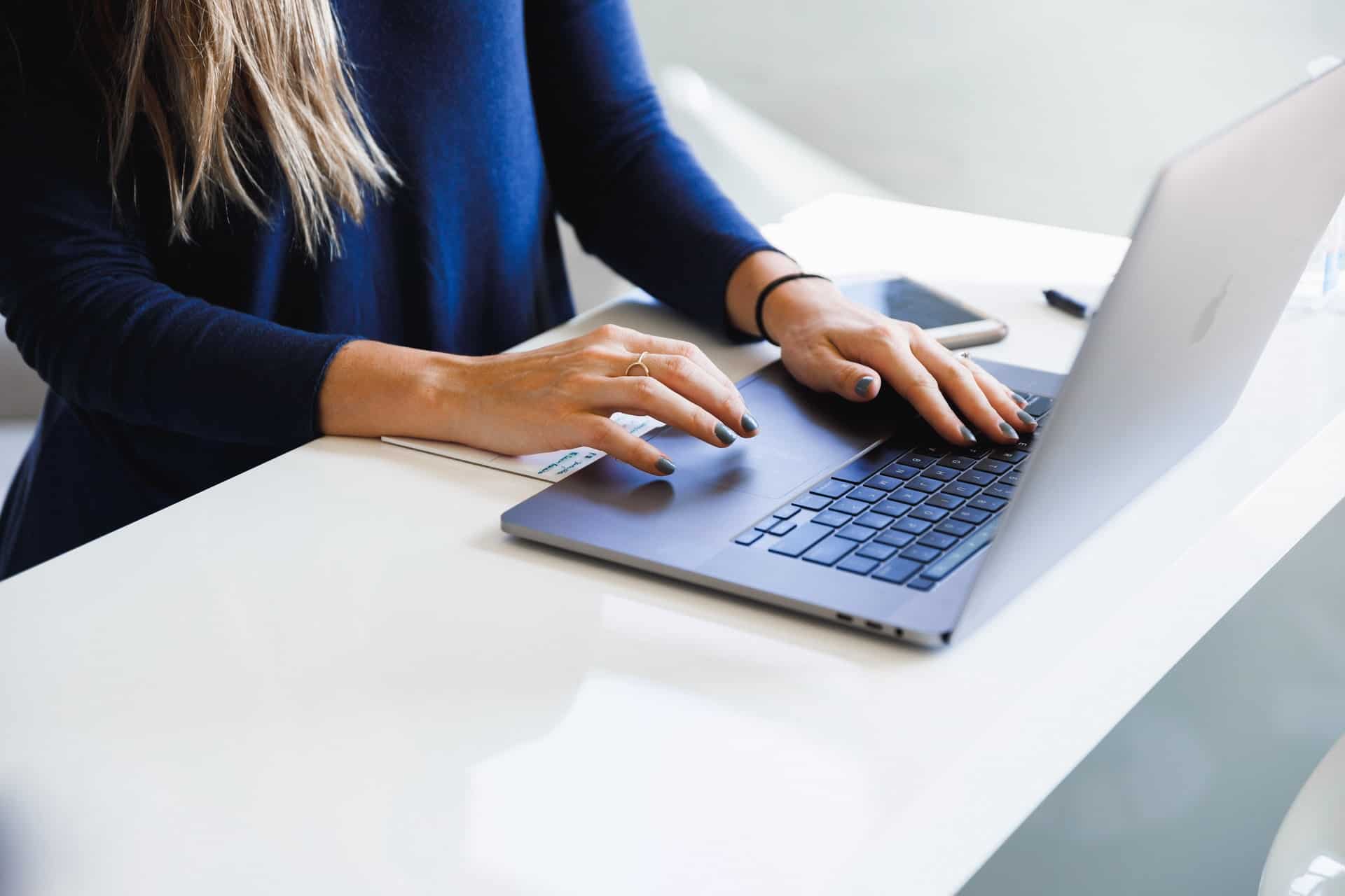 Mujer escribiendo en la computadora portátil