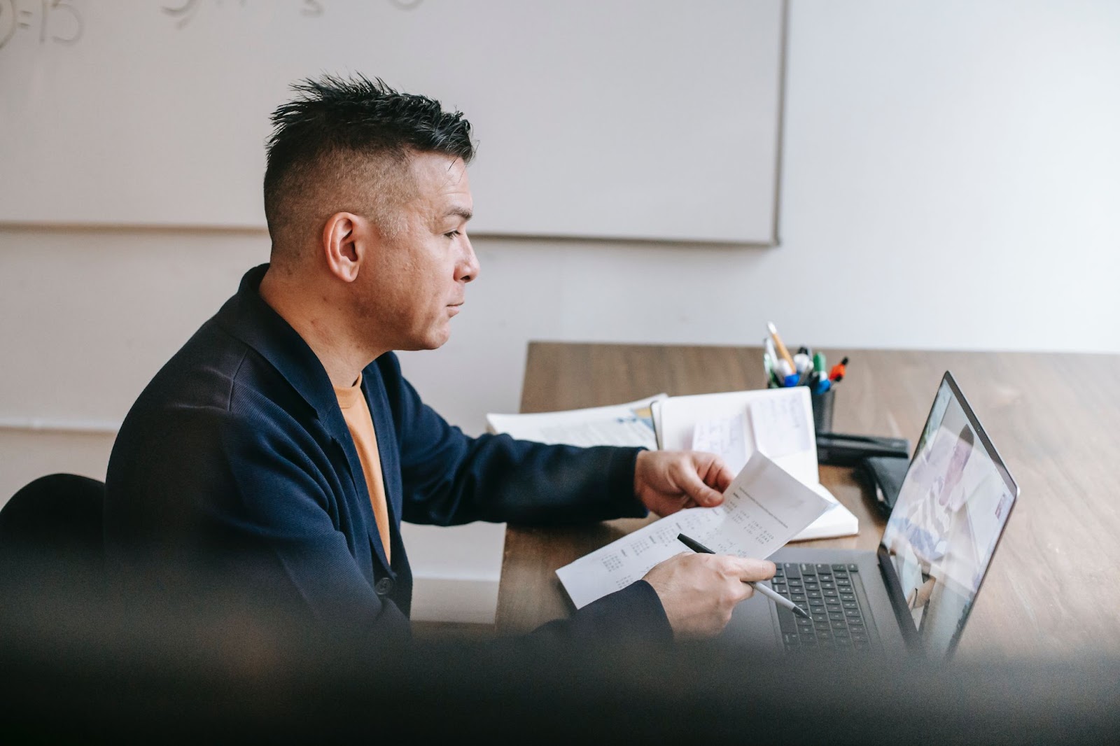 man-video-chatting-on-laptop-with-coworker-near-documents