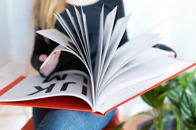 mujer leyendo un libro de diseño rojo