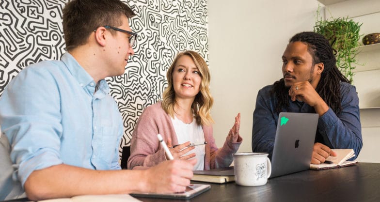 trois professionnels de l'agence discutent d'une stratégie