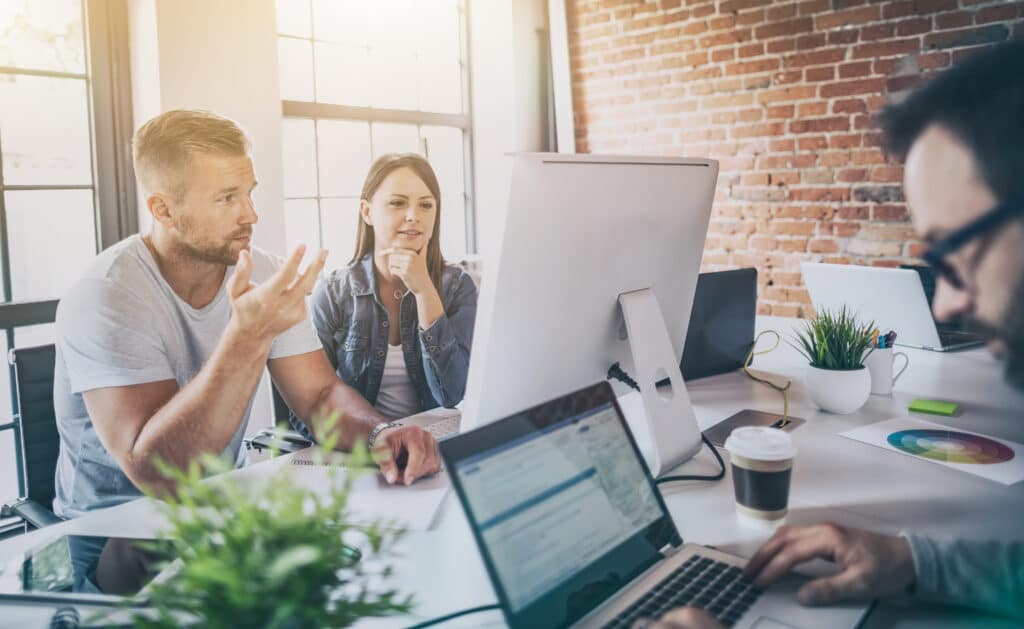 Orang yang bekerja di layar komputer yang berbeda di kantor