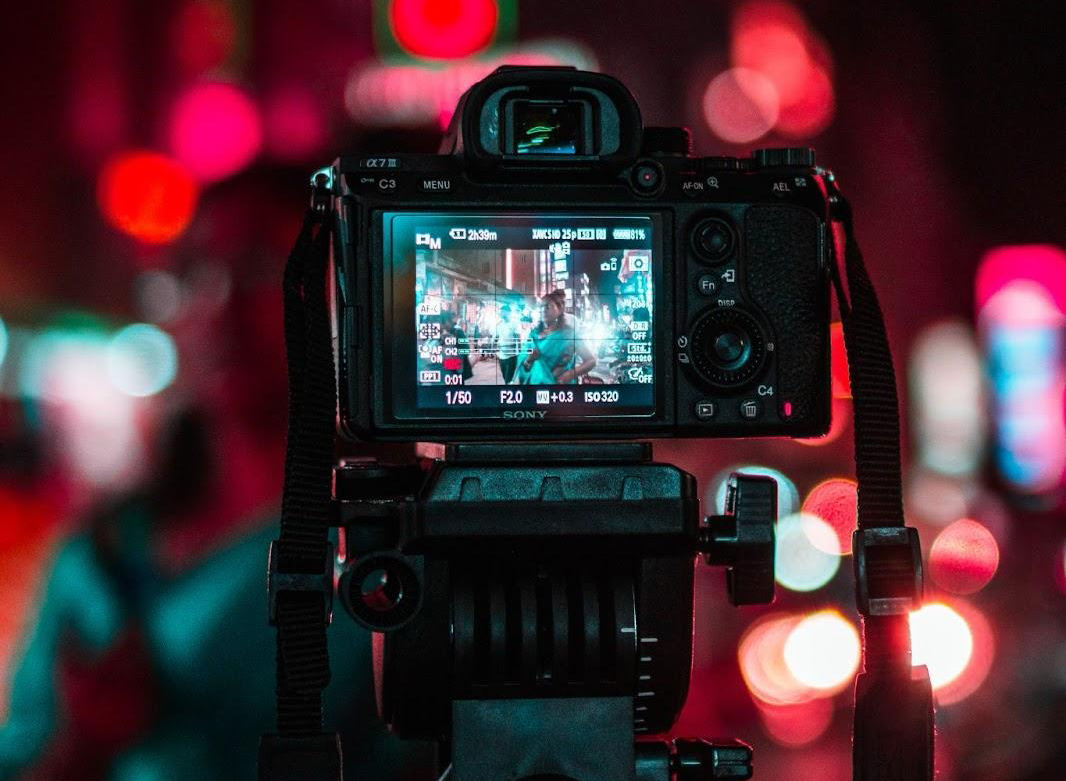 cámara tomando una foto de una calle concurrida e iluminada