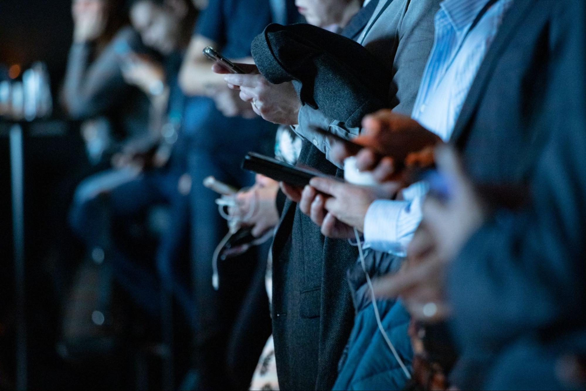 Foule de personnes utilisant des appareils mobiles.