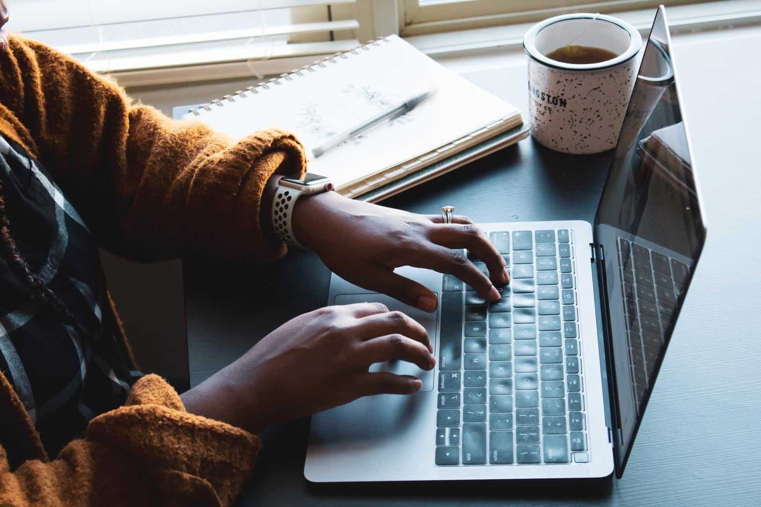 Taper sur un ordinateur portable avec du café