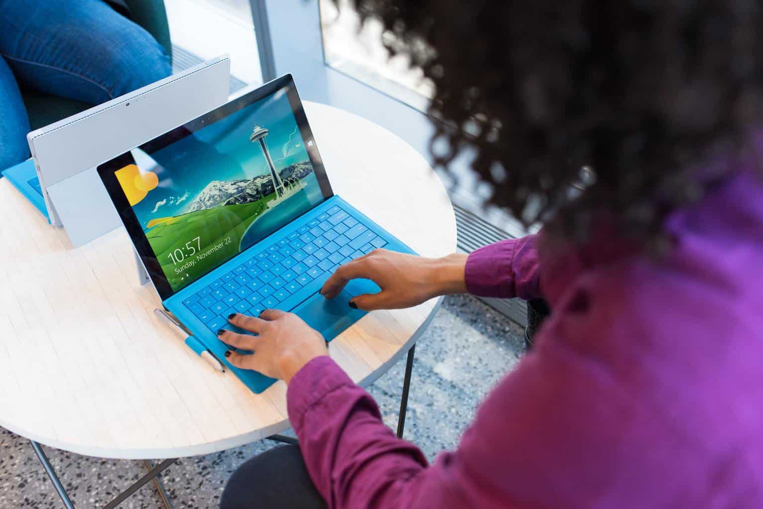 Frau tippt auf blauem Laptop