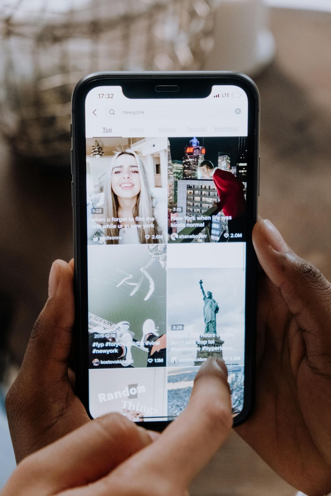 Deux paires de mains tiennent et pointent vers une application de médias sociaux sur un téléphone intelligent.