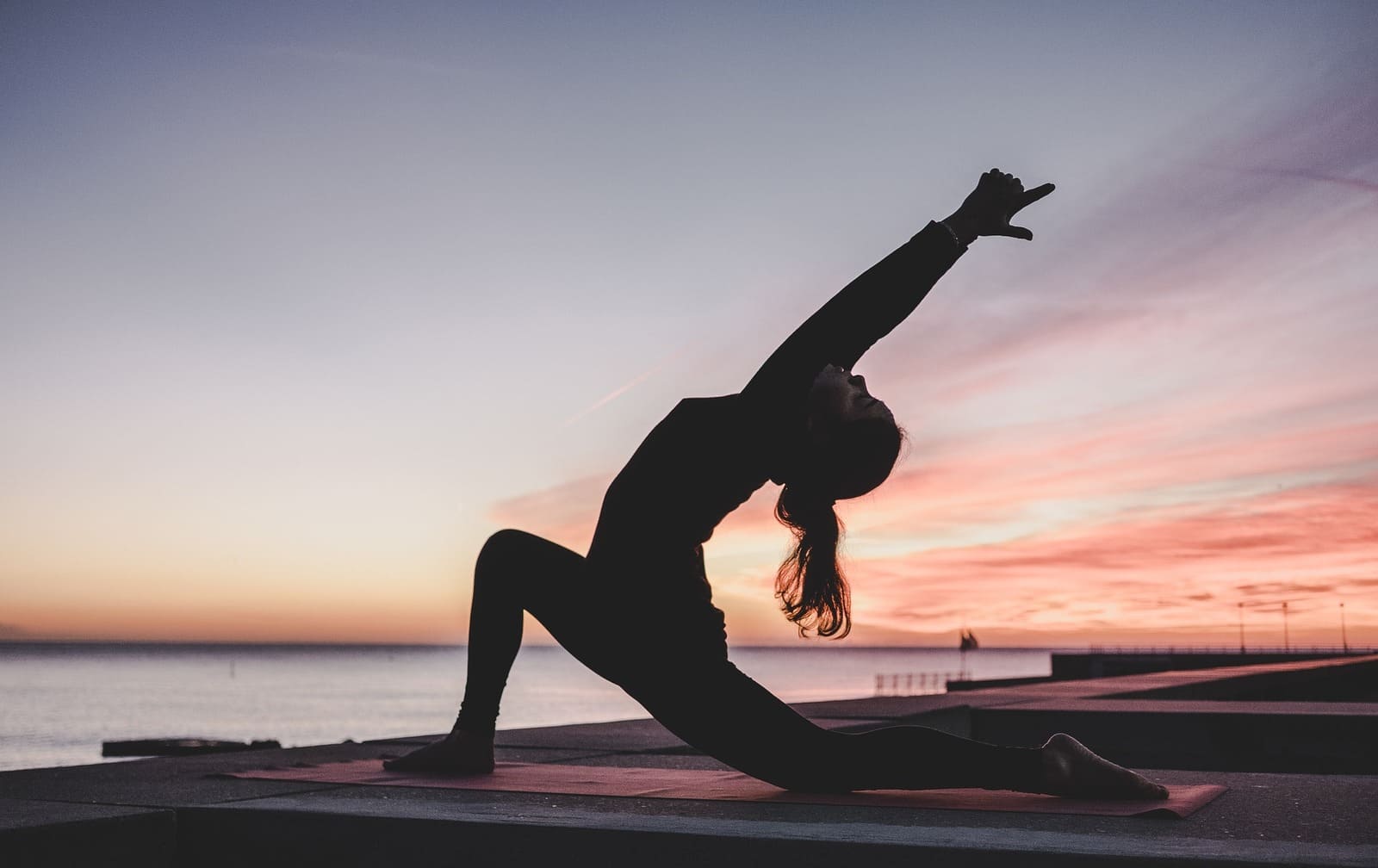 Foto aktivitas yoga di pantai, salah satu fasilitas kamar hotel yang populer.